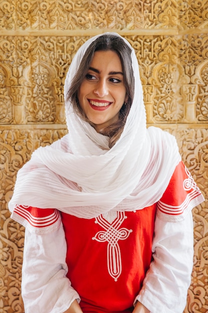 Muslim woman in front of golden wall