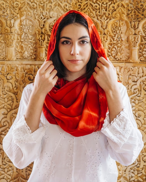 Muslim woman in front of golden wall