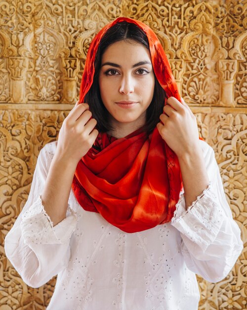 Muslim woman in front of golden wall