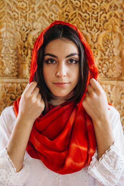 Muslim woman in front of golden wall