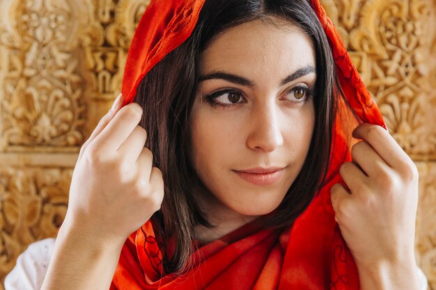 Muslim woman in front of golden wall