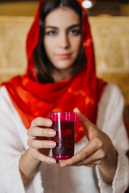 Muslim woman holding glass of tea