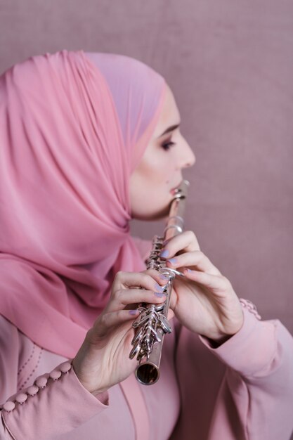 Muslim woman playing on the flute