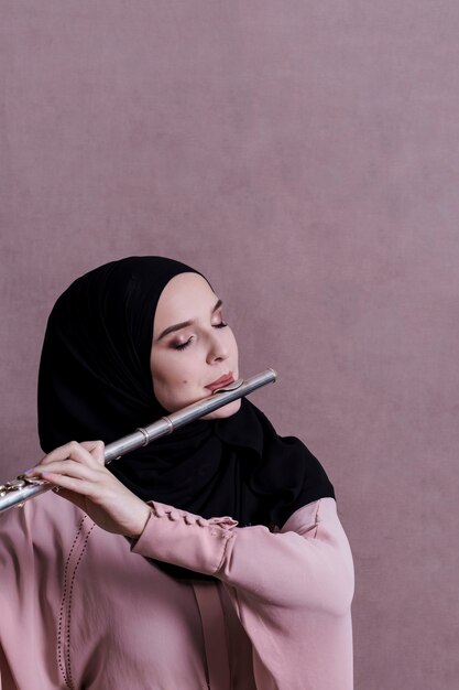 Muslim woman playing on the flute