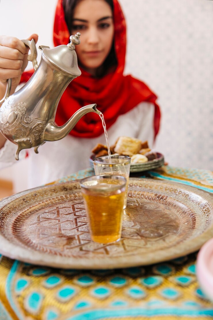 無料Photo イスラム教徒の女性が紅茶を注ぐ