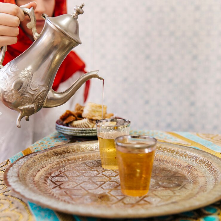 無料Photo イスラム教徒の女性が紅茶を注ぐ