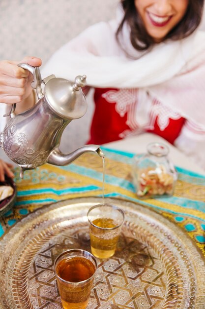 イスラム教徒の女性が紅茶を注ぐ