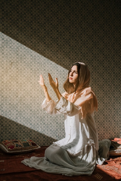 Muslim woman praying with sunlight effect