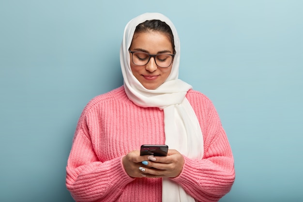 Foto gratuita donna musulmana che indossa un maglione rosa