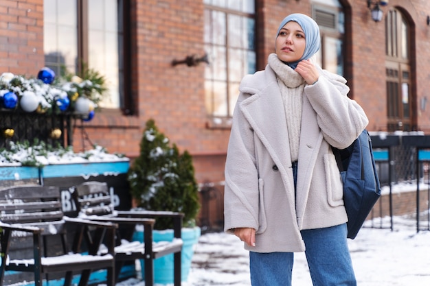 Muslim woman with hijab looking at the architecture of the buildings while traveling