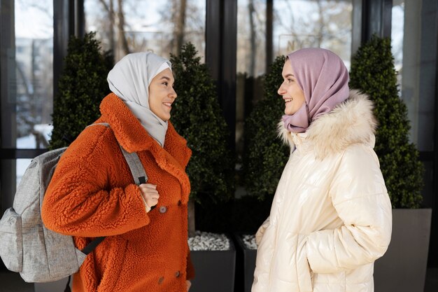 Muslim women talking in front of a hotel while being on vacation