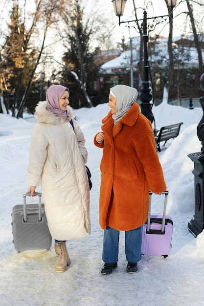 Muslim women walking with their luggage while being on vacation