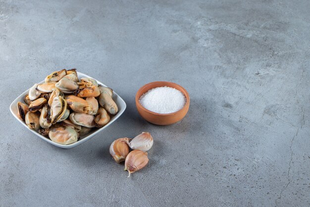 Mussels without shell in a bowl, on the marble background. 