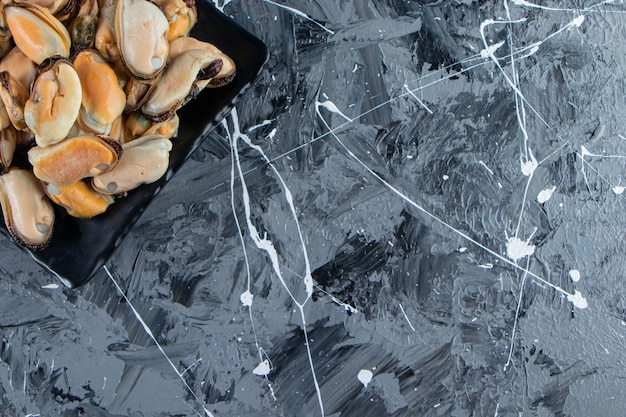 Free photo mussels without shell on a platter, on the marble background.