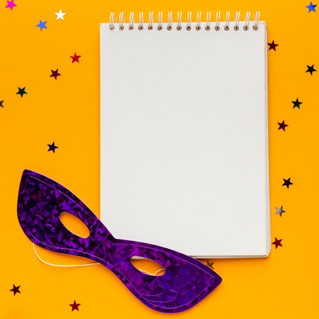 Free photo mysterious carnival mask notepad copy space