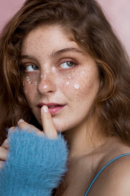 Mysterious freckled woman with white flowers on her face