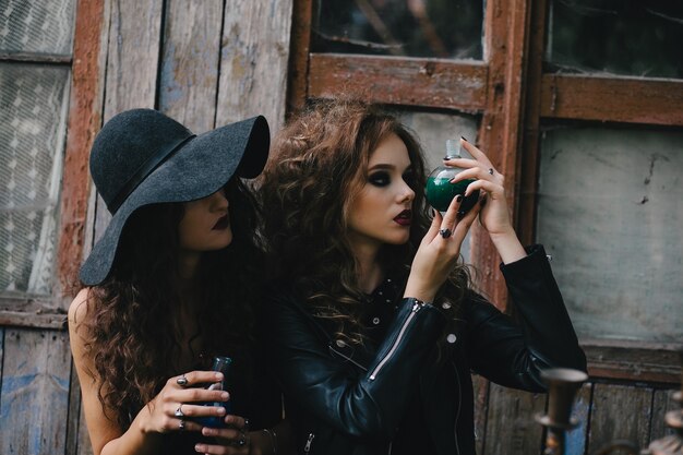 Mysterious sorceress observing a bottle with liquid