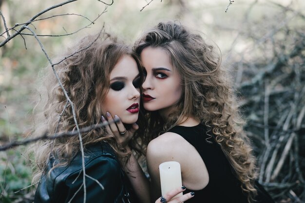 Mysterious witches posing with a candle