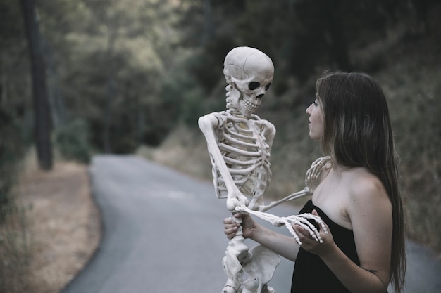 Mysterious woman holding skeleton