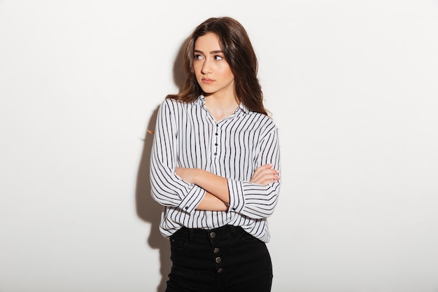 Mystery woman in shirt posing with crossed arms looking away