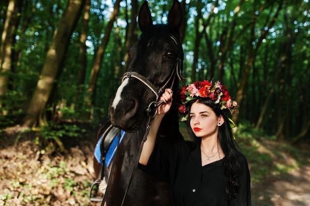 花輪の神秘的な女の子は木の馬と黒で着用します