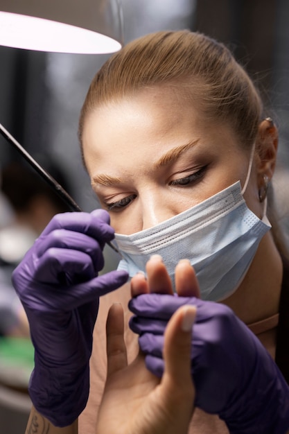 Nail art professional working on client nails