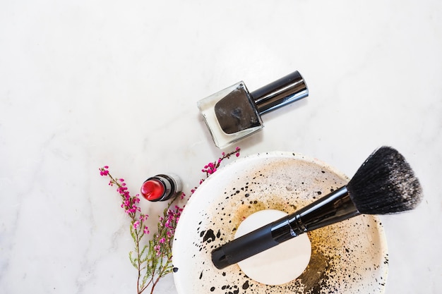 Nail polish and lipstick near bowl