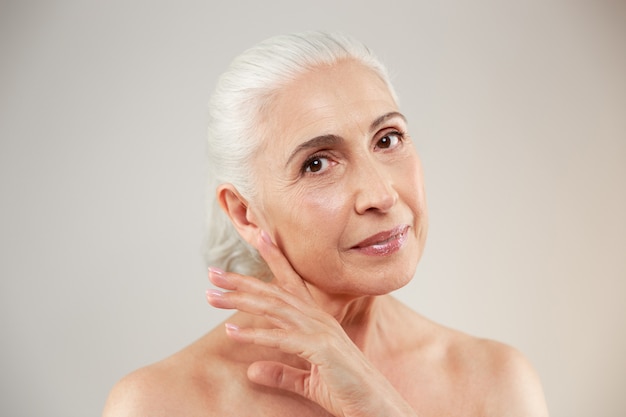 Naked elderly woman posing isolated