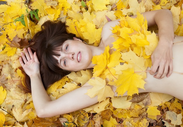 Naked girl  in maple leaves