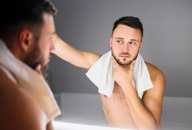 Naked man with bath towel around his neck