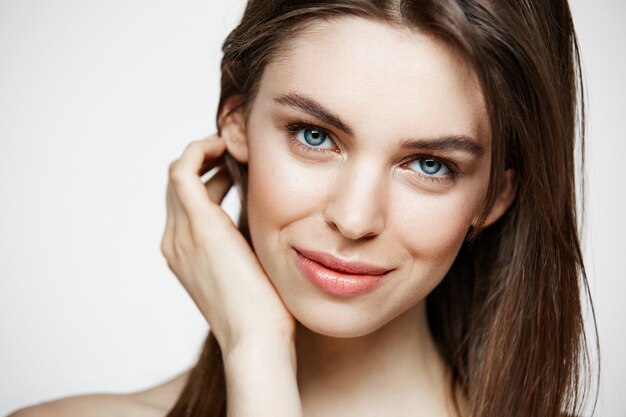 Naked young beautiful woman with natural make up smiling. Cosmetology and spa. Facial treatment.