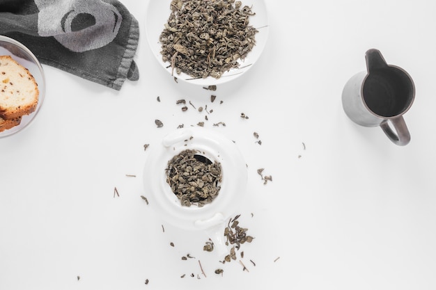 Napkin; bread with tea leaves and tea pot on white backdrop