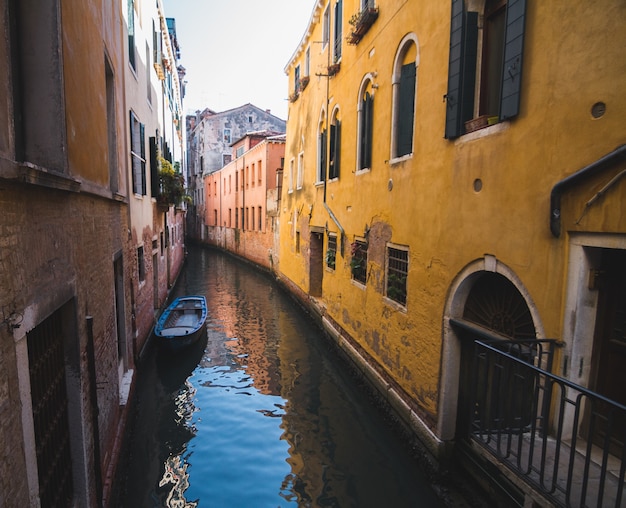 Narrow canal in the middle of buildings in Venice Italy