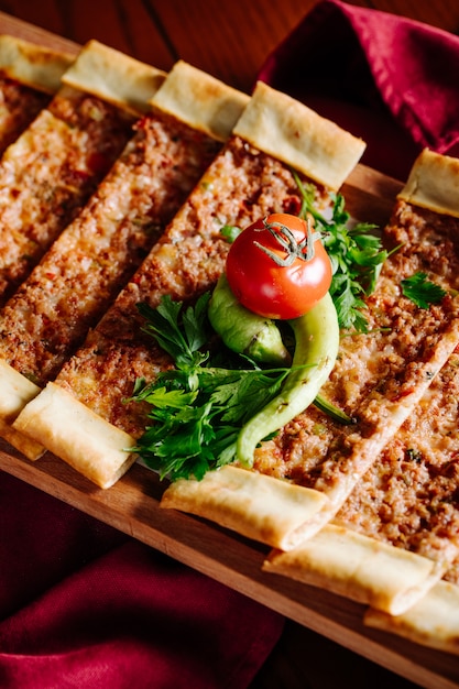 Narrow sliced traditional turkish lahmacun with herbs and vegetables.