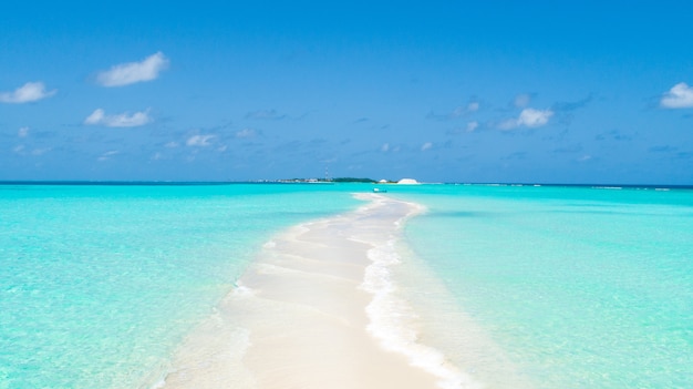 Narrow tip of an island covered by clean sand with clear water from both sides