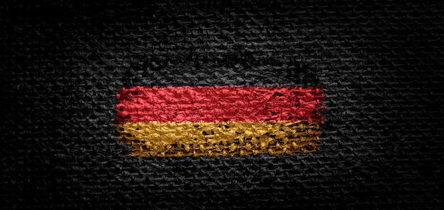 National flag of Germany on dark fabric.