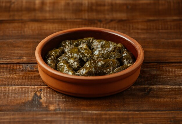 National food yarpaq dolmasi, grape leaves with meat inside, cooked inside a pottery bowl