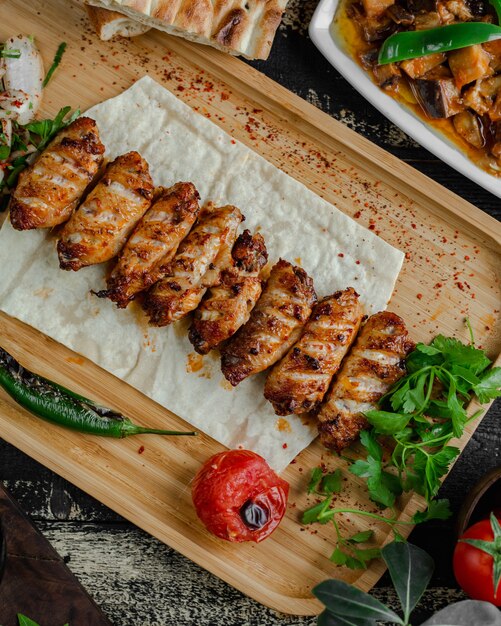 National meat barbecue kebab in lavash with parsley and grilled tomato.