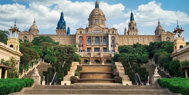 バルセロナの国立宮殿、スペインの庭園とその前の人々。曇り空