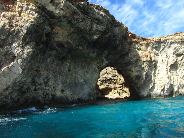 Natural arch surrounded by the sea under the sunlight at daytime in Comino in Malta