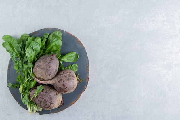 Natural beetroot on the board on the marble background.