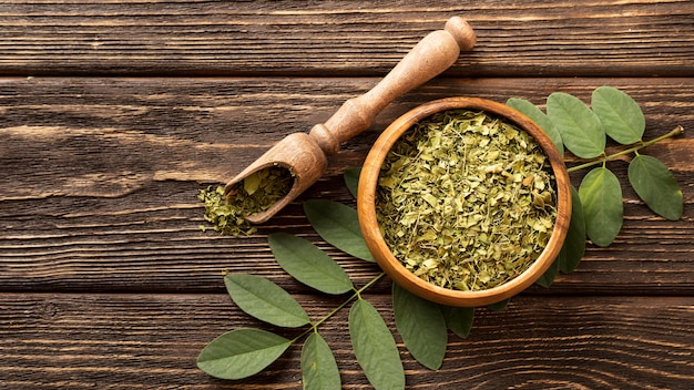 Natural crushed green leaves in a bowl top view