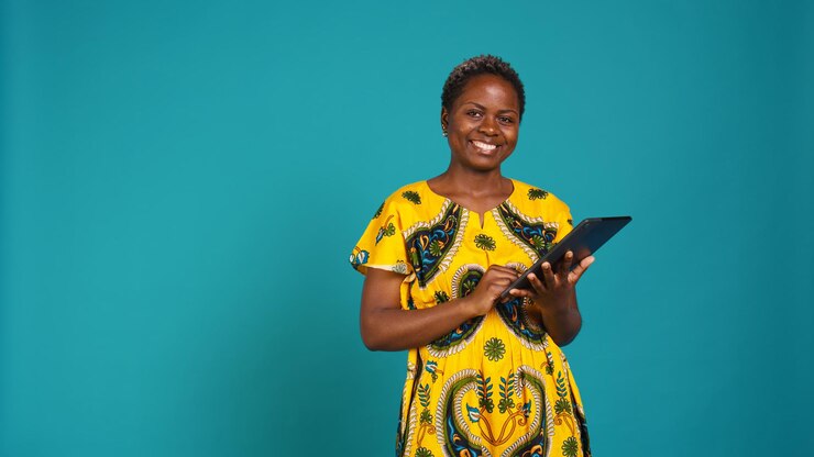 Free Photo natural cute girl browsing internet on a tablet against blue background