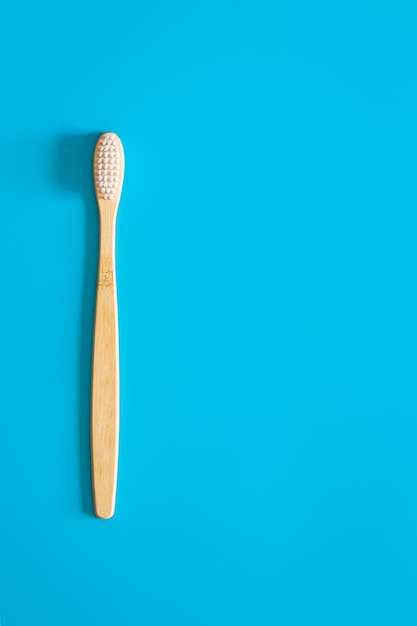 Free photo natural ecofriendly bamboo brush on a blue background copy space