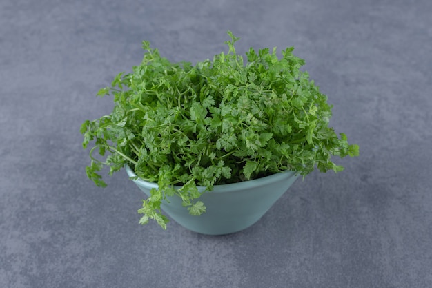 Natural greens in the bowl, on the marble surface.