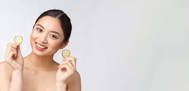 Natural homemade fresh cucumber facial eye pads facial masks Asian woman holding cucumber pads and smile relax with natural homemade