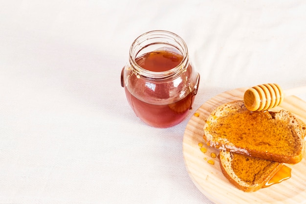 건강 한 아침 식사를위한 자연 꿀, 빵 흰색 표면에 고립