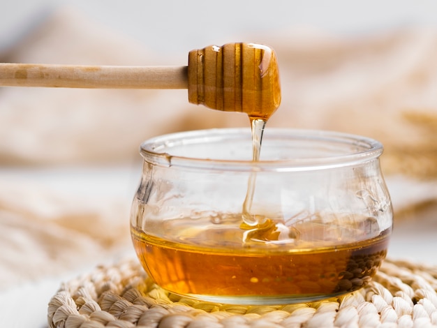 Natural honey pouring in bowl