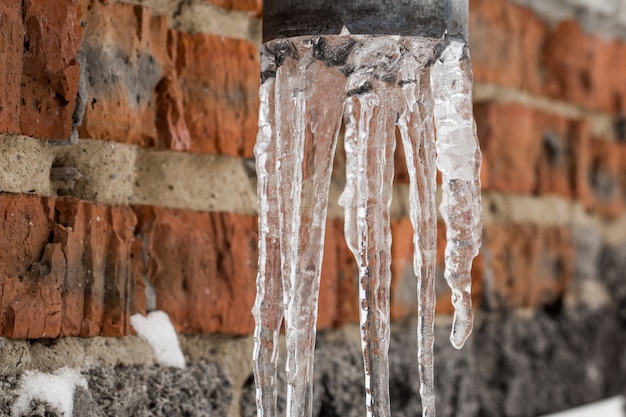 Free photo natural icicles hanging on the pipe