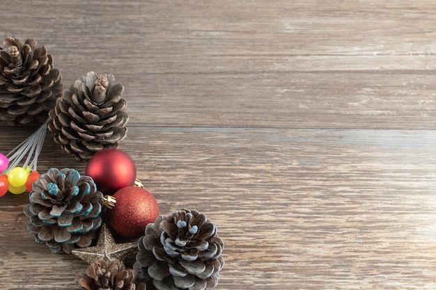 Natural oak tree cones on a wooden deck with glittering ornaments around